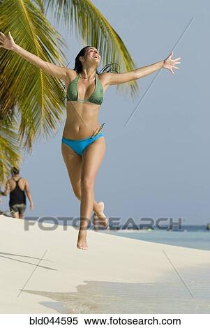 Hispanic woman jumping on beach View Large Photo Image Stock Photography - Hispanic woman jumping on beach. Fotosearch