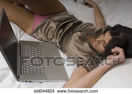 Picture - Hispanic woman looking at laptop. Fotosearch