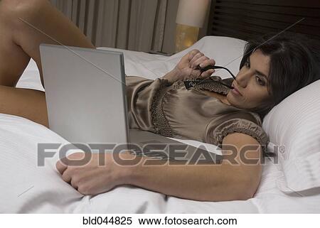Stock Photography - Hispanic woman looking at laptop. Fotosearch