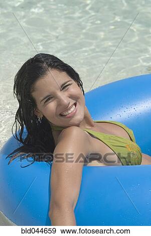 Stock Photo - Hispanic woman on float in water. Fotosearch