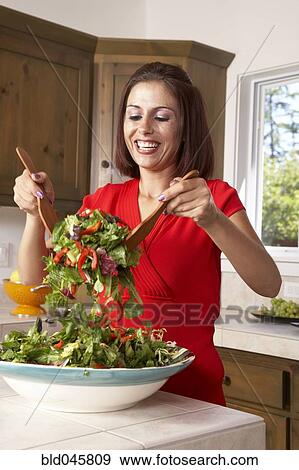 Stock Photo - Hispanic woman tossing salad. Fotosearch