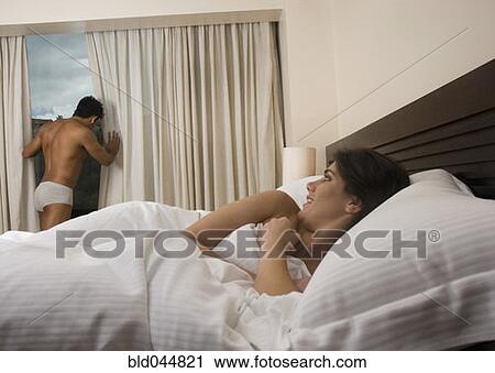 Hispanic woman watching husband from bed View Large Photo Image Stock Image - Hispanic woman watching husband from bed. Fotosearch
