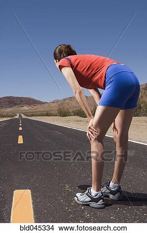 Picture - Mixed Race female runner on road. Fotosearch