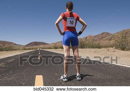 Stock Image - Mixed Race female runner on road. Fotosearch