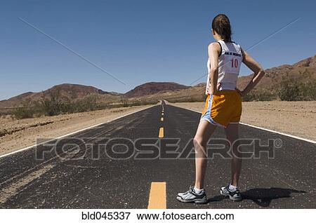 Stock Photo - Mixed Race female runner on road. Fotosearch