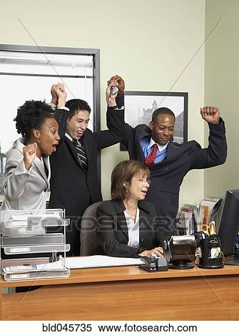 Stock Photography - Multi-ethnic businesspeople cheering. Fotosearch
