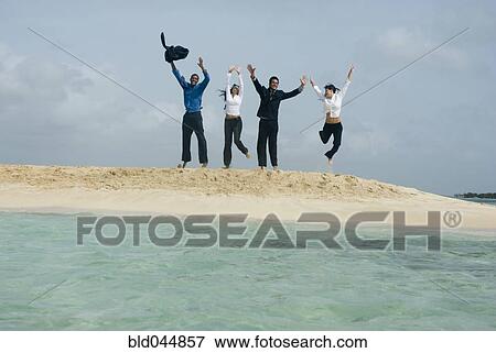 Multi-ethnic businesspeople jumping at beach View Large Photo Image Stock Photo - Multi-ethnic businesspeople jumping at beach. Fotosearch
