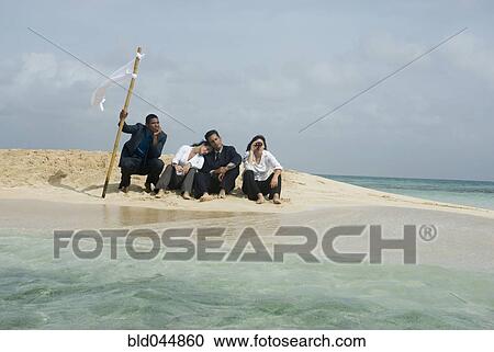 Stock Image - Multi-ethnic businesspeople with flag at beach. Fotosearch