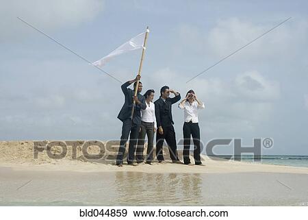 Stock Photo - Multi-ethnic businesspeople with flag at beach. Fotosearch