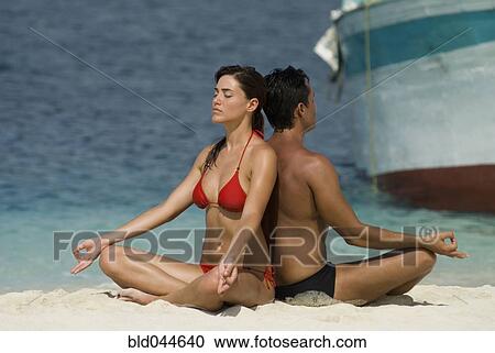 Multi-ethnic couple meditating at beach View Large Photo Image Stock Image - Multi-ethnic couple meditating at beach. Fotosearch