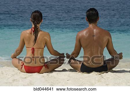 Multi-ethnic couple meditating at beach View Large Photo Image Stock Image - Multi-ethnic couple meditating at beach. Fotosearch