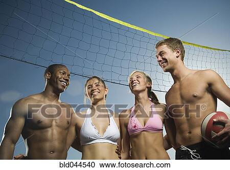 Multi-ethnic friends under beach volleyball net View Large Photo Image Stock Image - Multi-ethnic friends under beach volleyball net. Fotosearch