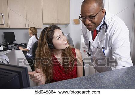 Picture - Multi-ethnic medical professionals looking at computer. Fotosearch