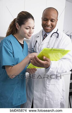 Multi-ethnic medical professionals discussing chart View Large Photo Image Picture - Multi-ethnic medical professionals discussing chart. Fotosearch