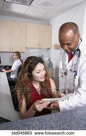 Stock Image - Multi-ethnic medical professionals discussing chart. Fotosearch