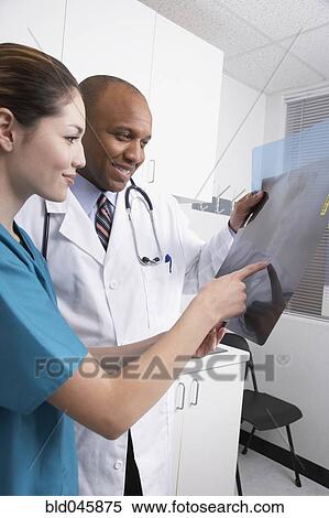 Stock Photography - Multi-ethnic medical professionals looking at x-rays. Fotosearch