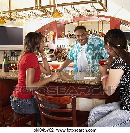 Multi-ethnic women sitting at bar View Large Photo Image Stock Image - Multi-ethnic women sitting at bar. Fotosearch