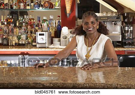 Stock Image - Portrait of African female bartender. Fotosearch