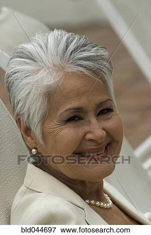 Stock Photo - Senior Hispanic woman in lounge chair. Fotosearch