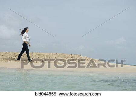 Woman carrying clock at beach View Large Photo Image Stock Photography - Woman carrying clock at beach. Fotosearch
