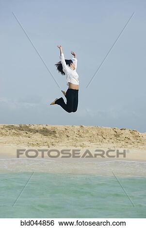 Woman jumping at beach View Large Photo Image Stock Photograph - Woman jumping at beach. Fotosearch