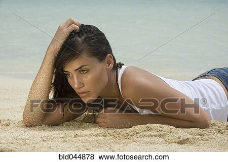 Stock Photo - Woman laying on beach. Fotosearch