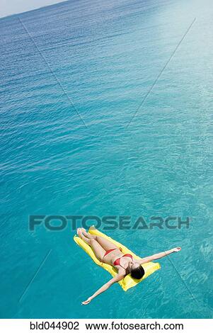 Woman on float in water View Large Photo Image Stock Image - Woman on float in water. Fotosearch