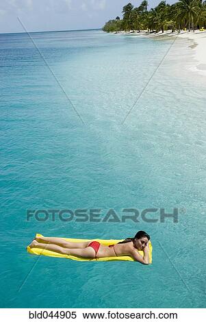 Woman on float in water View Large Photo Image Stock Photography - Woman on float in water. Fotosearch