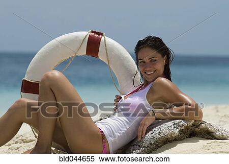 Young woman holding life preserver at beach View Large Photo Image Stock Photography - Young woman holding life preserver at beach. Fotosearch