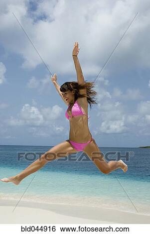 Young woman jumping at beach View Large Photo Image Stock Photograph - Young woman jumping at beach. Fotosearch