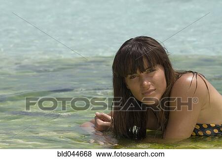 Young woman laying in water View Large Photo Image Stock Photo - Young woman laying in water. Fotosearch