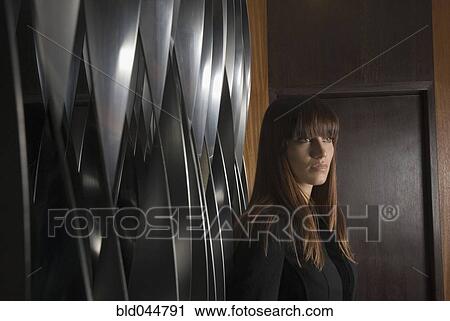 Young woman next to wall View Large Photo Image Stock Image - Young woman next to wall. Fotosearch