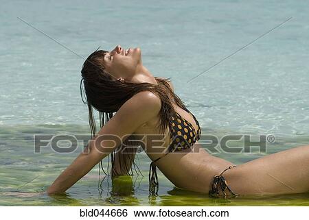 Young woman sitting in water View Large Photo Image Stock Photograph - Young woman sitting in water. Fotosearch