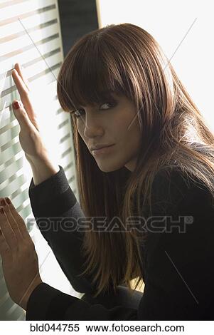 Stock Photography - Young woman with hands on glass door. Fotosearch