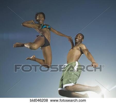 Stock Photo - African American couple jumping. Fotosearch