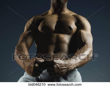 Stock Image - African American man flexing muscles. Fotosearch
