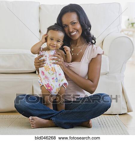 Stock Photo - African American mother and baby on floor. Fotosearch