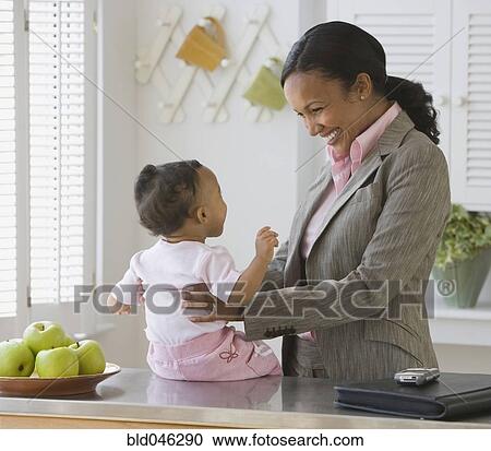 Stock Image - African American mother smiling at baby. Fotosearch