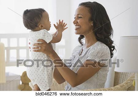 Stock Photograph - African American mother smiling at baby. Fotosearch