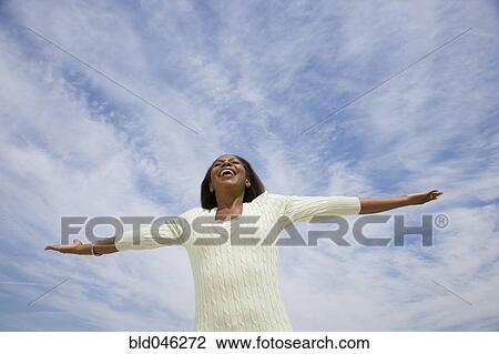 Stock Image - African American woman with arms outstretched. Fotosearch