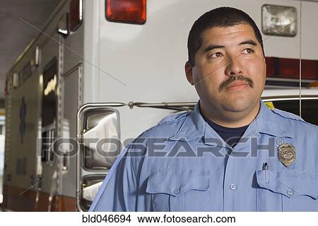 Picture - Asian male paramedic in front of ambulance. Fotosearch