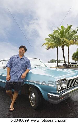 Asian man leaning on car View Large Photo Image Stock Photo - Asian man leaning on car. Fotosearch