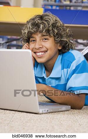 Stock Photo - Hispanic boy typing on laptop. Fotosearch