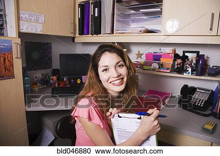 Stock Image - Hispanic businesswoman holding chart. Fotosearch