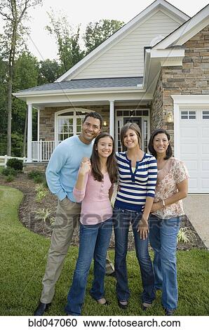 Stock Image - Hispanic family in front of house. Fotosearch