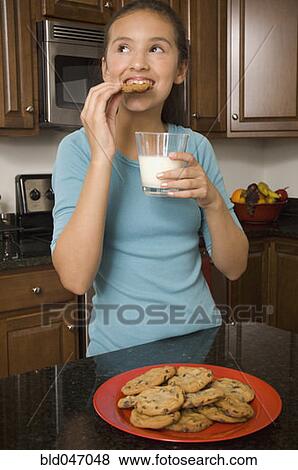 Stock Photo - Hispanic girl eating cookies. Fotosearch
