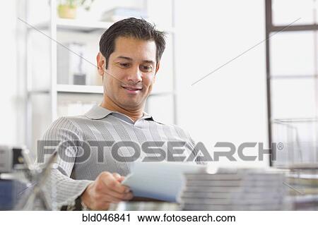 Hispanic man reading paperwork View Large Photo Image Stock Image - Hispanic man reading paperwork. Fotosearch