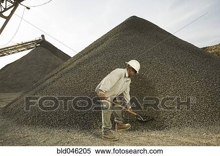 Stock Photography - Hispanic man shoveling gravel. Fotosearch