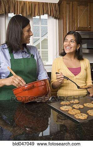 Stock Photo - Hispanic mother and daughter baking cookies. Fotosearch