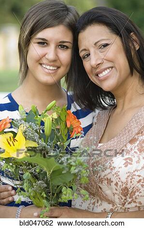 Hispanic mother and daughter holding flowers View Large Photo Image Stock Image - Hispanic mother and daughter holding flowers. Fotosearch